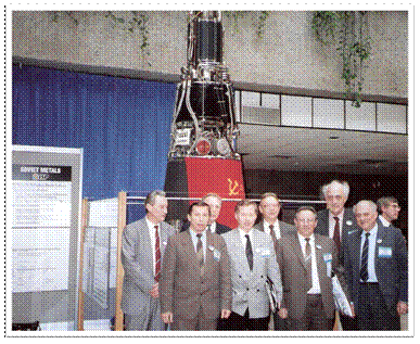 Figure 1: Soviet scientists led by Krasnaya Zvezda Director Georgiy Gryaznov (front center) with the TOPAZ-II display reactor at the New Mexico Space Nuclear Power Symposium, Albuquerque Convention Center, New Mexico, January 1991.